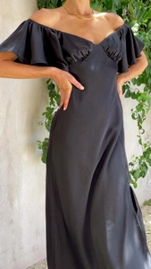 Détail des manches à volants et texture élégante en satin de cette robe noire à épaules dénudées