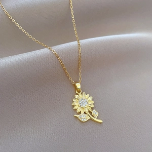 Luxurious gold sunflower pendant necklace with white zircon crystals on silk background