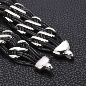 Macro shot of multi-strand black woven leather bracelet with polished silver metal clasp