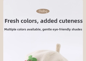 Detail shot of baby knitted beret featuring handmade cherry and leaf crochet ornaments