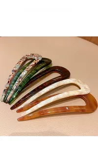 Detail of five U-shaped acetate hair forks in assorted marble and tortoise patterns