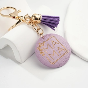 Close-up of purple mama keychain with leather tassel and round wooden leopard heart charm