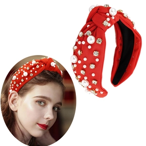 Detail of red fabric knotted headband decorated with white pearls and sparkling rhinestones