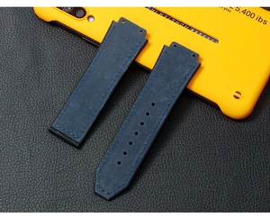 Detail of blue leather watch strap with matte texture and blue stitching on dark background