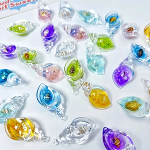 Close-up of colorful luminous shell charms with transparent resin and tiny natural shells