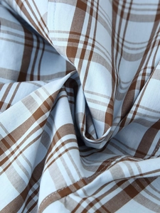 Detail of blue and brown checkered poplin fabric showing soft folds and fine texture
