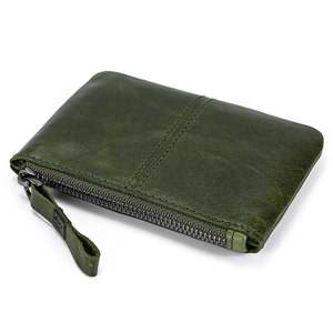 Detailed view of dark green genuine leather coin purse with metallic zipper on white background