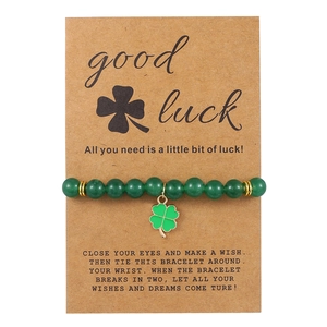 Detail of green natural stone clover bracelet on kraft paper gift card with gold accents