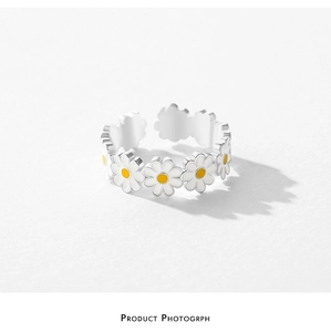 Detailed close-up of S925 silver daisy ring with white enamel petals and adjustable band