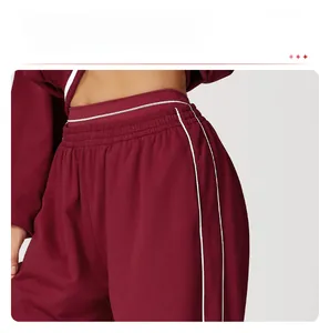 Gros plan détaillé du jogging bordeaux avec taille élastique et bandes latérales blanches