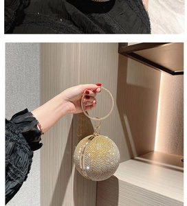 Close-up of a sparkling gold rhinestone spherical evening bag with a round handle