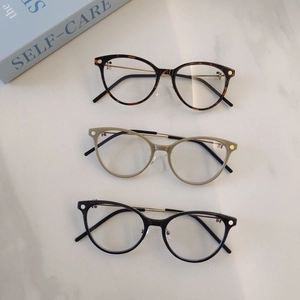 Retro round glasses in tortoiseshell and black on marble background with book