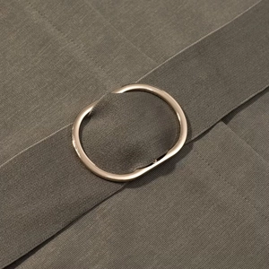 Detailed macro view of army green woven dress fabric with a gold metallic oval belt buckle