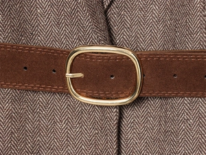 Close-up of brown suede belt with oval gold buckle over herringbone wool suit texture
