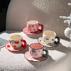 Detailed set of four ceramic coffee cups and saucers with hand-painted heart and floral motifs