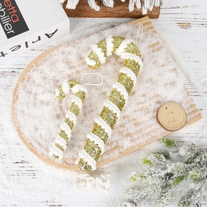 Macro shot of glitter gold Christmas candy cane ornaments with white snow texture details