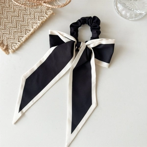 Detail shot of black and white oversized bow scrunchie with elegant long ribbons