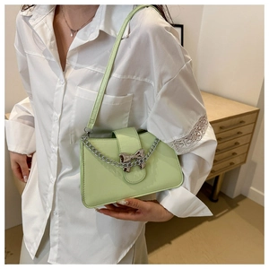 Detail of mint green crossbody bag featuring silver chain and metal bow decoration