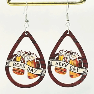 Détail de boucles d'oreilles en bois avec texte Beer Day et motif de tasses à bière
