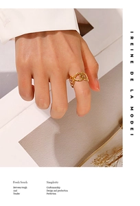 Close-up of heart-shaped hollow ring in gold finish worn on finger for elegance