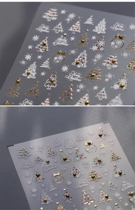 Macro view of 5D embossed Christmas nail stickers with gold snowflake and tree patterns