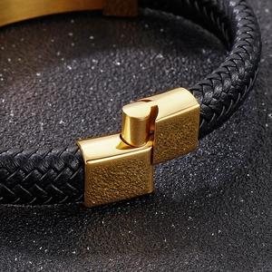 Close-up of interlocking gold magnetic clasp on black braided leather men's bracelet