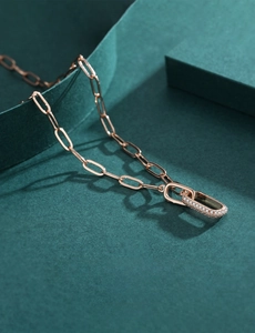 Macro detail of rose gold paperclip chain necklace with micro-paved rectangle pendant