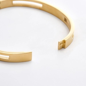 Polished gold stainless steel bracelet featuring zircon stones and hollow clasp detail