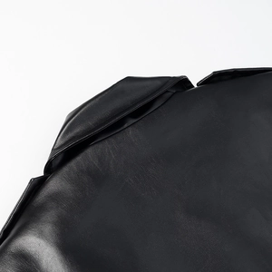 Detailed close-up of premium black leather coat showing fine stitching and glossy texture
