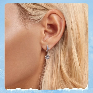 Close-up of elegant S925 sterling silver snowflake earrings worn by a model