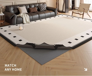 Detail showing the gray anti-slip backing of a beige chenille rug with black geometric borders
