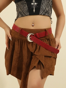 Detail of red crocodile pattern belt with crescent buckle on model wearing brown skirt