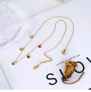 Macro shot of 18K gold chain with five-color round gems and K18 hallmark detail