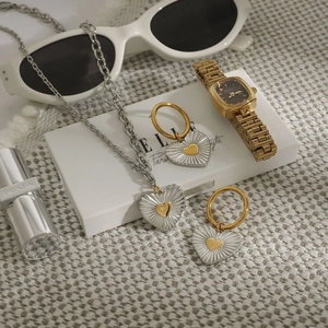 Two-tone 18k gold stainless steel heart pendant necklace and earrings set on a white box
