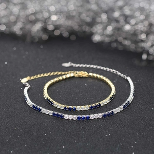 Macro shot of silver and gold tennis bracelets with deep blue and clear cubic zirconia stones