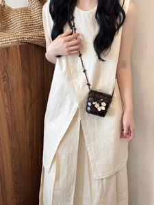 Detail of bohemian handmade coconut shell mini crossbody bag with a white floral accent
