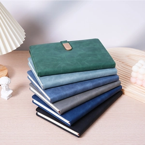 Minimalist A5 business notebooks with PU leather covers and magnetic buckle on wooden desk