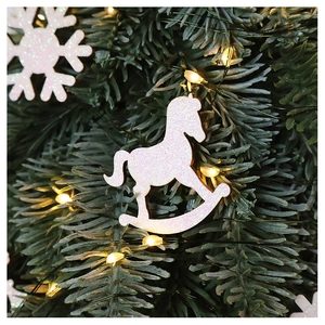 Pink glitter rocking horse ornament hanging on Christmas tree with snowflake and warm lights
