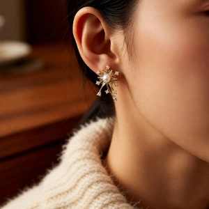 Vue détaillée des boucles d'oreilles flocon en perle et or portées par un mannequin