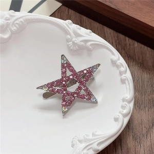 Close-up of Y2K star hair clip with pink rhinestones and iridescent gems on metal base