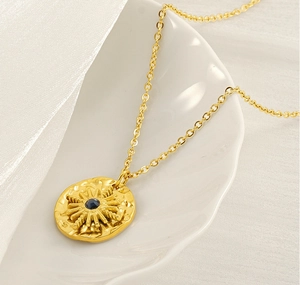 Détail du collier étoile dorée serti d'une pierre bleu marine sur une assiette blanche
