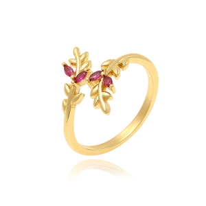 Elegant gold leaf ring with micro-set red gemstones on a clean white reflective surface