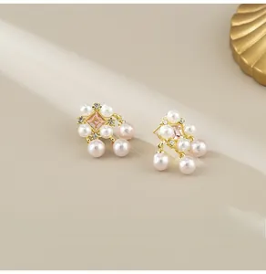 Detailed close-up of French vintage style pearl earrings with pink crystals and gold finish