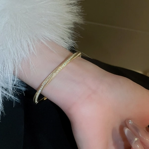 Macro detail of gold-plated bangle with double rows of pavé-set cubic zirconia crystals