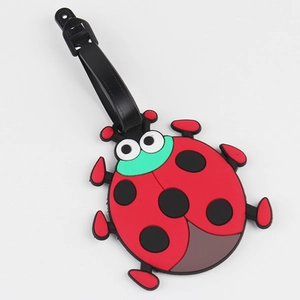 Cute red ladybug silicone luggage tag with black spots and leather strap on white background