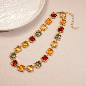 Detail of vintage gold necklace with square frames and colorful oval resin stones