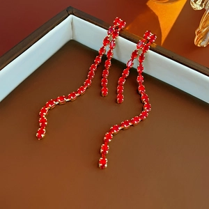 Detailed view of red crystal teardrop tassel earrings on a premium jewelry box base