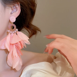 Close-up of pink fabric petal tassel earrings with beads on a model for a sweet resort look