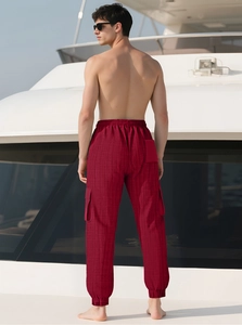 Détail d'un pantalon cargo à carreaux rouges avec de grandes poches et cordon de serrage