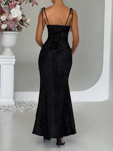 Detailed back view of a black evening dress featuring lace-up straps and jacquard fabric